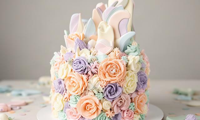 Tarta de primer cumpleaños con número grande y flores de crema en colores pastel
